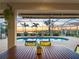 Outdoor dining setup on a screened patio with tranquil views of the pool and waterfront at 5035 Collingswood Blvd, Port Charlotte, FL 33948