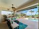Relaxing covered patio with comfortable seating, overhead fan, and views of the pool and waterfront at 5035 Collingswood Blvd, Port Charlotte, FL 33948