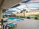 Inviting screened-in pool area with lounge chairs, scenic views, and lush landscaping at 5035 Collingswood Blvd, Port Charlotte, FL 33948