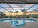A screened-in pool features a lovely water feature and sunset views overlooking the water at 5035 Collingswood Blvd, Port Charlotte, FL 33948