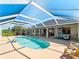 Pool with an outdoor kitchen, pool chairs and a view of the waterfront at 5035 Collingswood Blvd, Port Charlotte, FL 33948