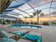 Serene screened-in pool with lounge chairs, tropical plants, and sunset views at 5035 Collingswood Blvd, Port Charlotte, FL 33948