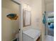 Coastal powder room featuring a single vanity and decorative fish art at 5035 Collingswood Blvd, Port Charlotte, FL 33948