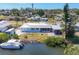 Aerial view of a waterfront home with a metal roof, boat lift, and lush landscaping at 507 Buena Vista Dr, Nokomis, FL 34275