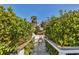 Scenic walkway leading to a private boat dock surrounded by lush greenery and waterfront views at 507 Buena Vista Dr, Nokomis, FL 34275