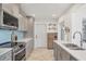 Modern kitchen with stainless steel appliances, gray cabinets, and quartz countertops at 507 Buena Vista Dr, Nokomis, FL 34275