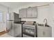 Convenient laundry area featuring modern washer, dryer, utility sink, stainless fridge, and stylish gray cabinetry at 507 Buena Vista Dr, Nokomis, FL 34275