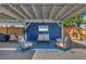 Relaxing covered patio with comfortable furniture, TV, ceiling fan, and views of the lovely garden at 507 Buena Vista Dr, Nokomis, FL 34275
