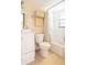 Clean bathroom with a white toilet, vanity, mirror, and a shower-tub combination, featuring neutral tile and yellow accents at 510 Airport E Ave # 2C, Venice, FL 34285