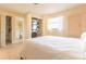 Bright bedroom featuring a queen-sized bed, ample closet space, and an adjoining bathroom with laundry facilities at 510 Airport E Ave # 2C, Venice, FL 34285