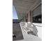 Exterior view highlighting the cottage facade, cozy Adirondack chairs, and covered walkway at 510 Airport E Ave # 2C, Venice, FL 34285