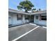 Charming exterior view of cottages with white siding, red shutters, and Adirondack chairs at 510 Airport E Ave # 2C, Venice, FL 34285