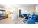 Open concept living area featuring a blue sofa adjacent to a kitchen with stainless steel appliances and bar seating at 510 Airport E Ave # 2C, Venice, FL 34285