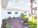 Outdoor patio area featuring brick pavers, gray Adirondack chairs, and lush landscaping at 510 Airport E Ave # 2C, Venice, FL 34285