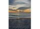 Picturesque sunset seascape with dramatic clouds reflecting in the water as the sun dips below the horizon at 510 Airport E Ave # 2C, Venice, FL 34285