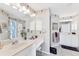 Bright bathroom features dual sinks, vanity, walk-in shower, and floral wallpaper at 5189 Pine Shadow Ln, North Port, FL 34287