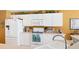 Kitchen with white cabinets, stainless appliances, and decorative accents at 5189 Pine Shadow Ln, North Port, FL 34287