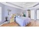Bedroom with tray ceilings, wood floors, and a view of the en suite bathroom at 5189 Pine Shadow Ln, North Port, FL 34287