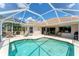 Sparkling screened-in pool with sunburst design and access to a covered patio at 5189 Pine Shadow Ln, North Port, FL 34287