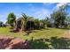 Backyard features a spacious lawn, tropical landscaping, and a screened lanai for outdoor enjoyment at 5255 Layton Dr, Venice, FL 34293