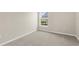 This bedroom features neutral walls, light carpet and a window to the outdoors at 5255 Layton Dr, Venice, FL 34293