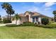 Single story home with lush green lawn, two car garage, and beautiful landscaping at 5255 Layton Dr, Venice, FL 34293