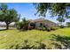 A rear exterior shows lush landscaping, a patio and green lawn at 5255 Layton Dr, Venice, FL 34293
