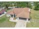 Aerial view of property showing roofline, multiple garages, and lush surrounding trees at 5417 Maccaughey Dr, North Port, FL 34287