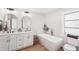 Modern bathroom with double vanities, stylish fixtures, a standalone soaking tub, and neutral decor at 5417 Maccaughey Dr, North Port, FL 34287