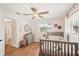 Bright bedroom with wood floors, neutral walls, ceiling fan, two windows and a decorative wreath on the crib at 5417 Maccaughey Dr, North Port, FL 34287