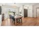The dining area features a rustic wooden table and light hardwood floors adjacent to a front door at 5417 Maccaughey Dr, North Port, FL 34287
