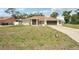 A single-story home with a well-manicured lawn and an extra long driveway at 5417 Maccaughey Dr, North Port, FL 34287