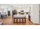 Open kitchen with white cabinetry, stainless steel appliances, a center island with seating, and wood floors at 5417 Maccaughey Dr, North Port, FL 34287