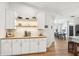 An open design with white cabinetry, wood floors, and a coffee bar overlooking the dining area at 5417 Maccaughey Dr, North Port, FL 34287