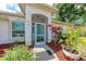 Inviting front porch with turquoise door and a well-manicured garden at 5766 Stone Pointe Dr, Sarasota, FL 34233