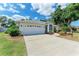 Beautifully landscaped single-story home with a two-car garage, screen porch, and inviting curb appeal at 5766 Stone Pointe Dr, Sarasota, FL 34233