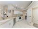 Bright kitchen featuring white appliances and cabinets, neutral countertops, and tile flooring at 5766 Stone Pointe Dr, Sarasota, FL 34233