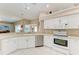 Bright kitchen featuring white appliances, cabinets, neutral countertops, and tile flooring at 5766 Stone Pointe Dr, Sarasota, FL 34233
