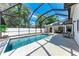 Screened-in pool and patio area with luxurious lounge chairs, landscaping and privacy fence at 5766 Stone Pointe Dr, Sarasota, FL 34233