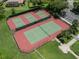 Aerial view of the tennis courts surrounded by lush green landscaping and manicured grounds at 615 May Apple Way, Venice, FL 34293