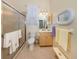 A well-lit bathroom features a glass-enclosed shower, a vanity, and decorative accents for a clean, fresh look at 615 May Apple Way, Venice, FL 34293