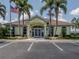 A clubhouse with manicured landscaping, ample parking, and inviting entrance provides a welcoming community gathering place at 615 May Apple Way, Venice, FL 34293