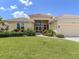 Inviting yellow home with a tile roof, a well-kept lawn, and a two-car garage at 615 May Apple Way, Venice, FL 34293