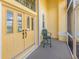 Inviting front entrance featuring double doors, transom window, and a cozy sitting area on the porch at 615 May Apple Way, Venice, FL 34293