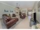 Open-concept living room with tile floors, leather furniture, and ample natural light at 615 May Apple Way, Venice, FL 34293