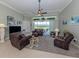 Inviting living room with comfortable leather seating, ceiling fan, and serene backyard views at 615 May Apple Way, Venice, FL 34293