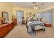 Inviting bedroom with a ceiling fan, soft lighting, and windows dressed in elegant curtains at 615 May Apple Way, Venice, FL 34293