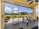 Screened-in lanai with comfortable seating, perfect for enjoying the serene views of the backyard and garden at 615 May Apple Way, Venice, FL 34293