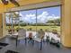 Screened lanai with comfortable seating, providing a relaxing view of the lush backyard landscaping at 615 May Apple Way, Venice, FL 34293
