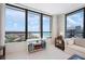 Well-lit living room with a bookcase and stunning ocean views from large windows at 627 Alhambra Rd # 1103, Venice, FL 34285